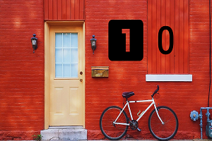 An image of a red wall with a door and a bike