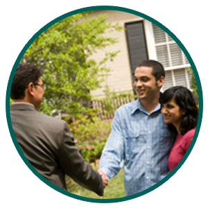 A young couple shaking hands with a man in a suit in front of a home, similar to how Alliance Property Management will welcome new tenants to your rental property covered by our Windsor property management.